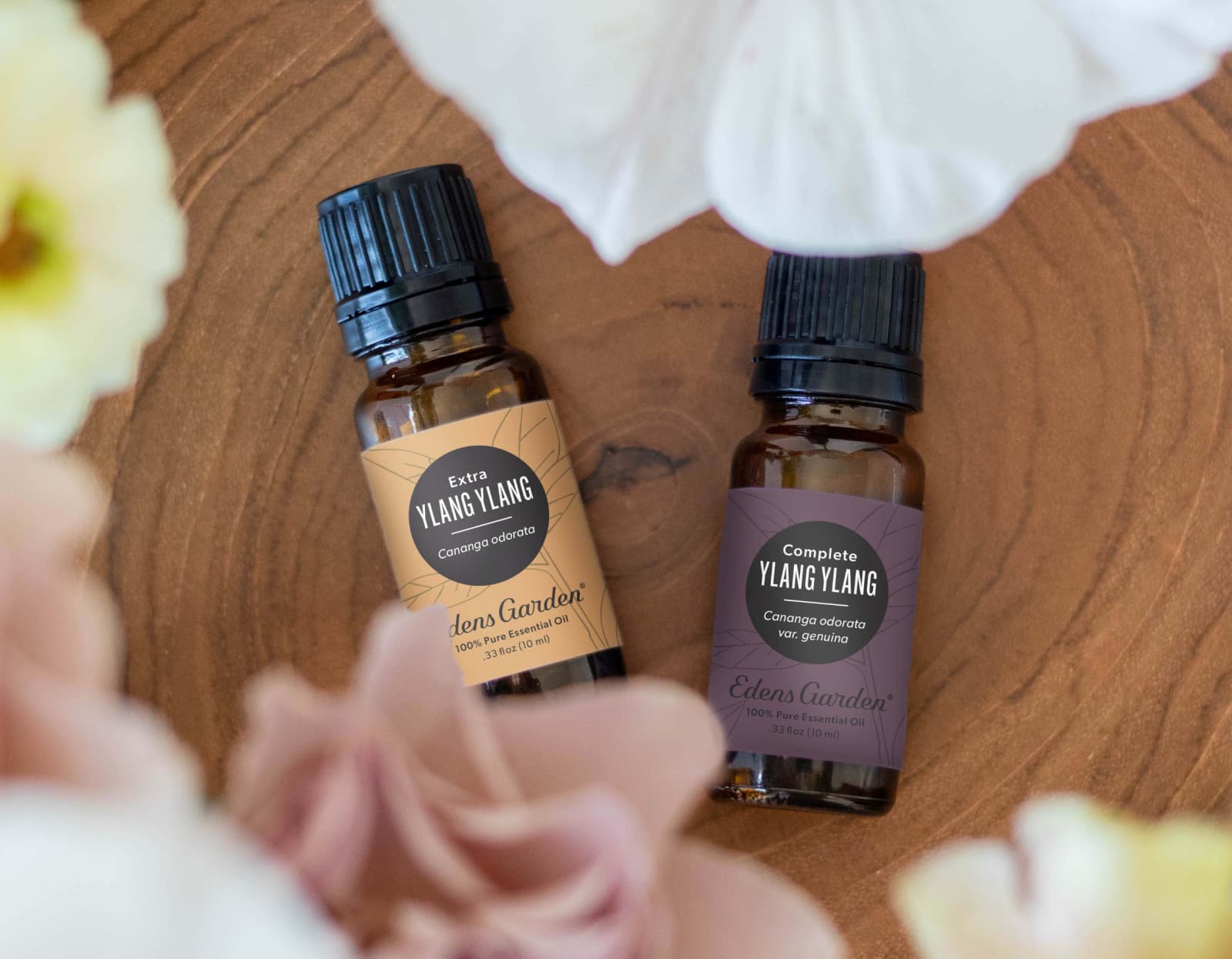 Essential oils laying flat on a wood with flowers in the foreground