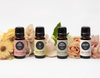 Rose Bergamot, Joy, Vanilla Sandalwood and Skin Love synergy blends in front of flowers