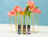 Clary Sage, Sweet Marjoram and Lavender-Spike essential oil in front of Ranunculus flower arrangement