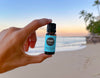 Hand holding Spearmint essential oil at the beach