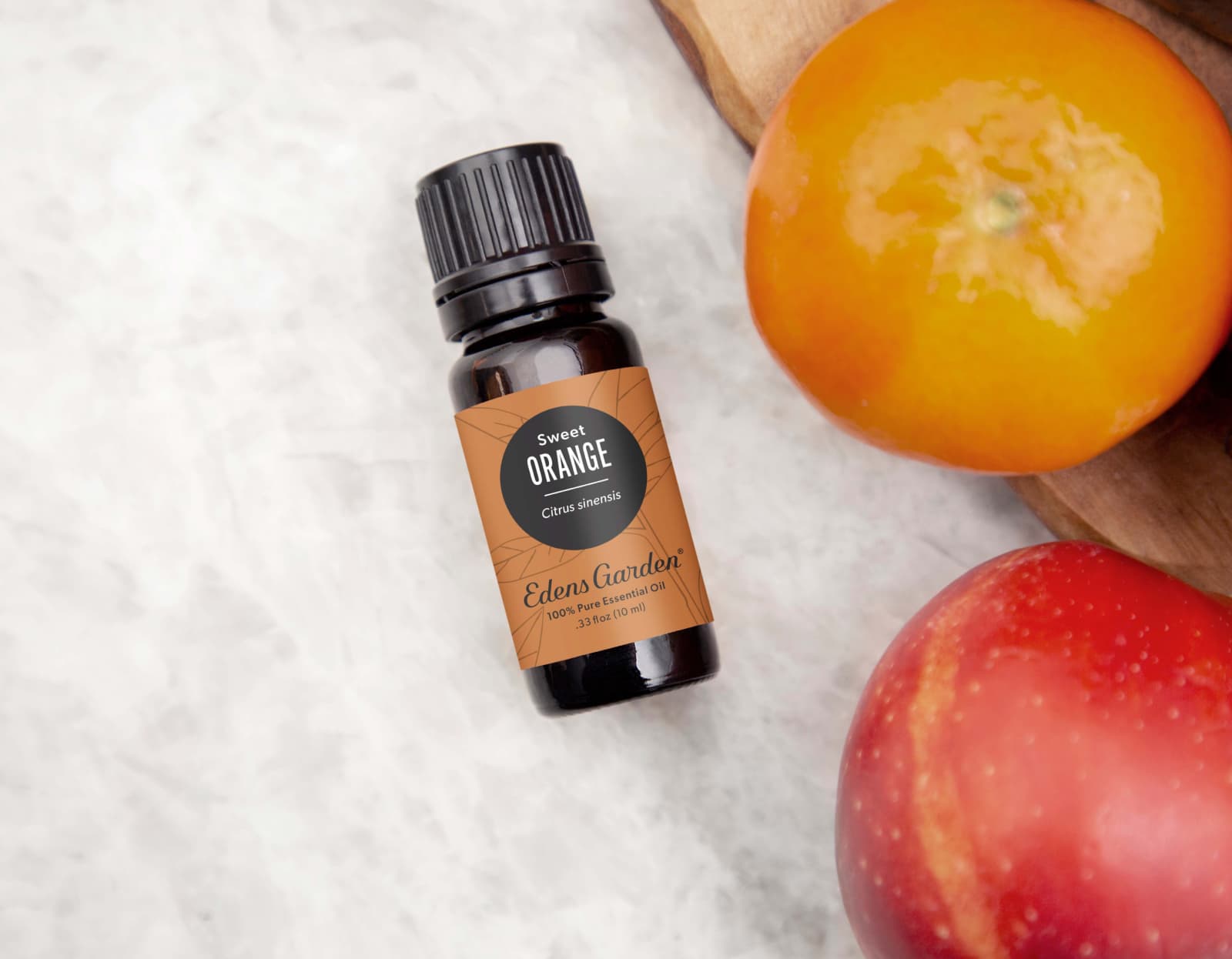 Flat lay of Orange-sweet essential oil next to fruits