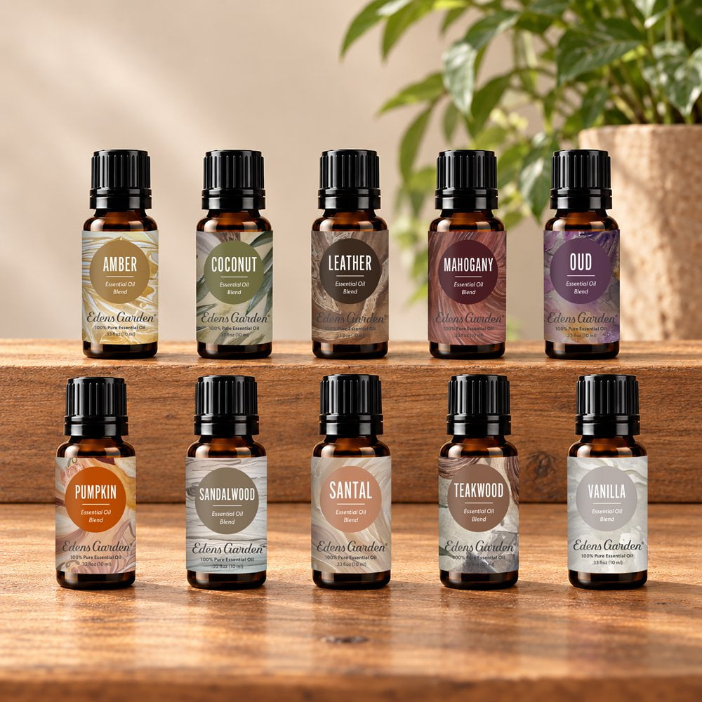 Eight amber glass essential oil bottles with black caps arranged on wooden shelves and a tabletop. Each bottle has a different color label matching a scent name: Amber, Coconut, Leather, Magogany, Oud, Pumpkin, Sandalwood, Santal, Teakwood, and Vanilla.