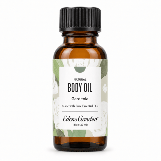 Edens Garden Natural Body Oil in Gardenia scent, in a 1 fl oz (30 ml) amber glass bottle with a black ribbed cap and a white label with green botanical illustrations.