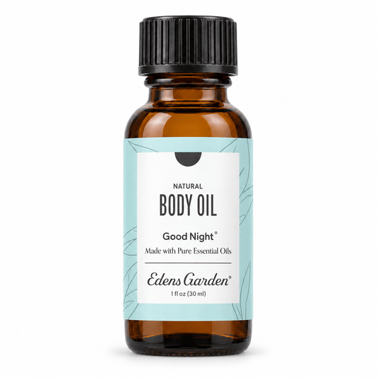 A 1 fl oz amber glass bottle of Edens Garden Natural Body Oil with a black ribbed cap and a light blue and white label, shown on a plain white background.