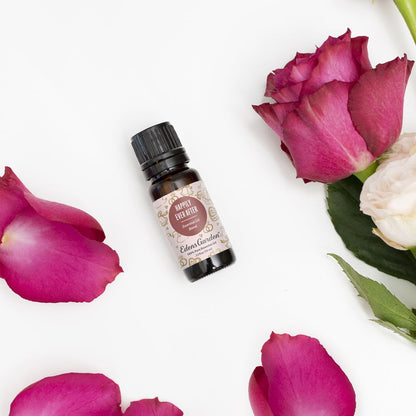Essential oil bottle with pink roses and petals on a white background