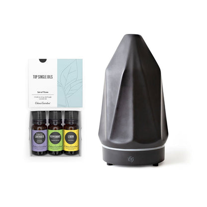 Black diffuser with essential oil bottles on a white background