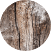 A circular close-up of a rustic wood texture with natural grain, knots, and weathered brown tones.